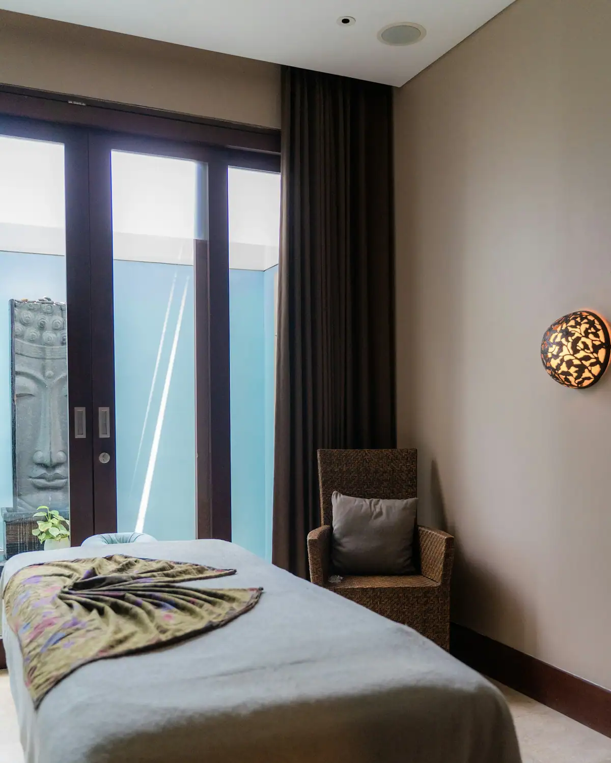 A room with a gray-draped massage table