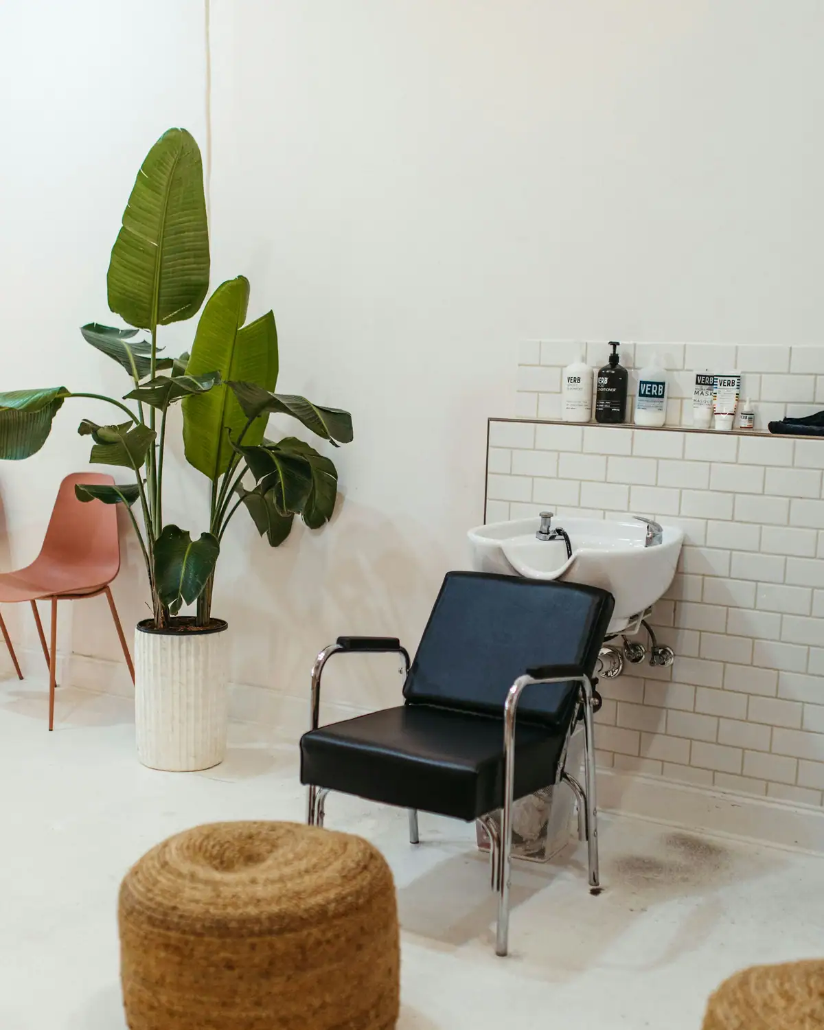 Shampoo chair, a plant and a wicker pouf