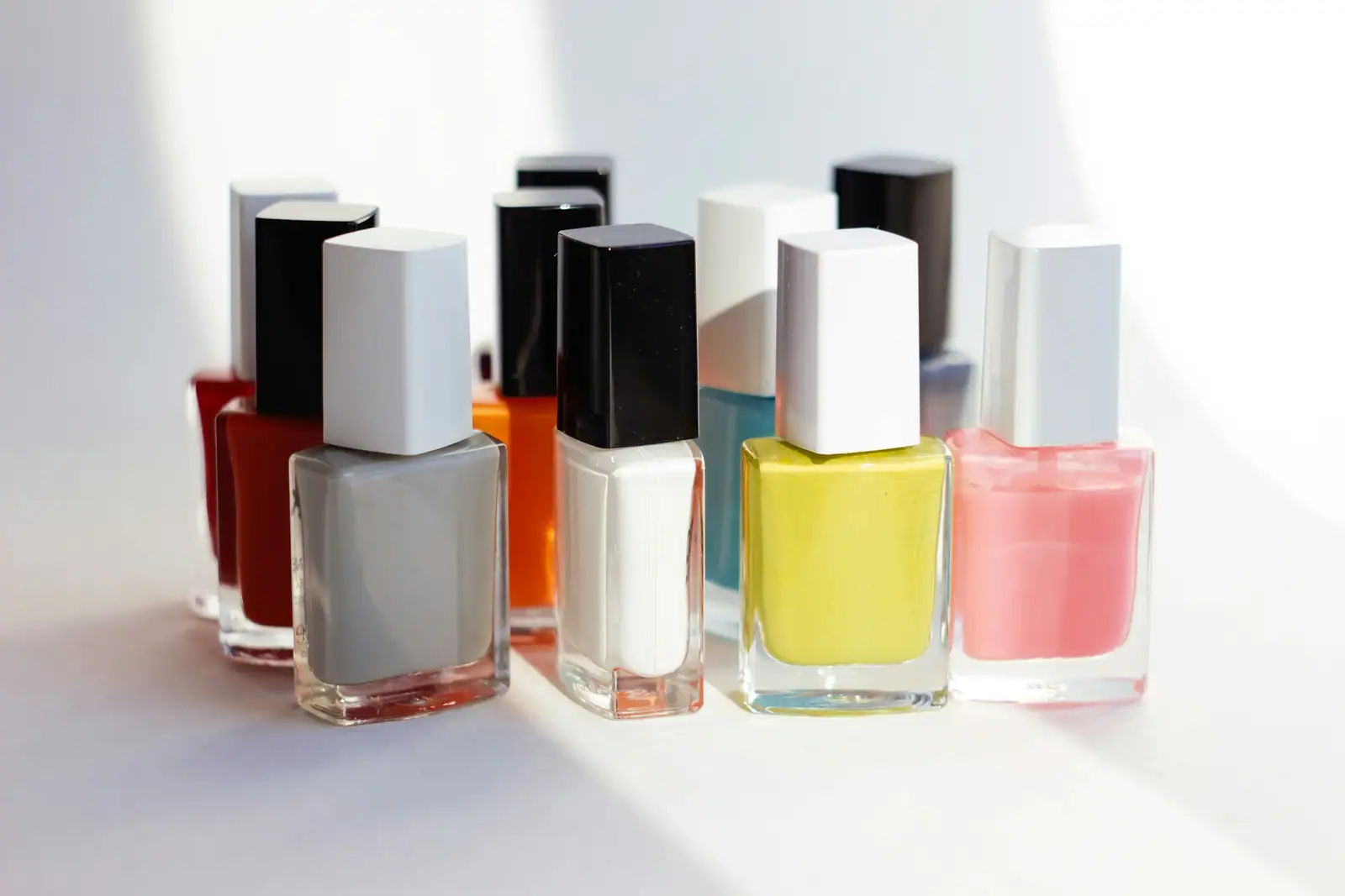 Nail polish bottles lined up on a white background