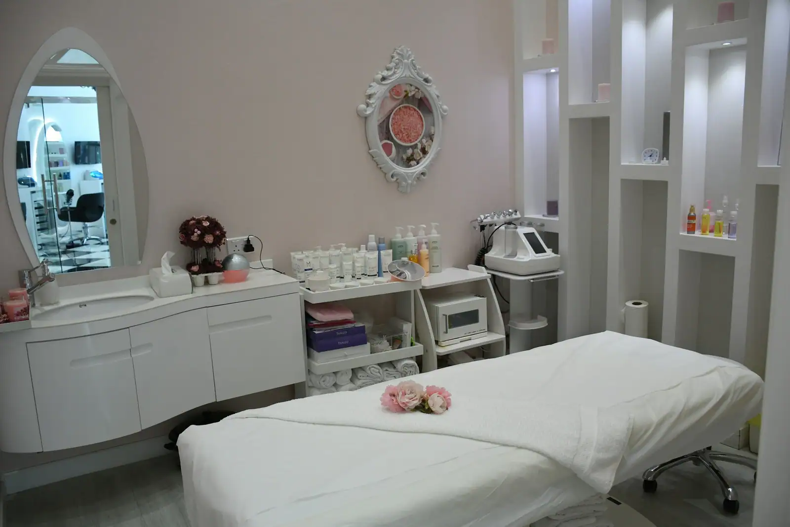 A room with a treatment bed and product shelves