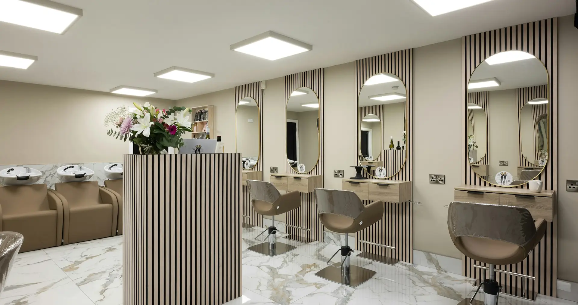 Salon with marble floors, arched mirrors and champagne tones