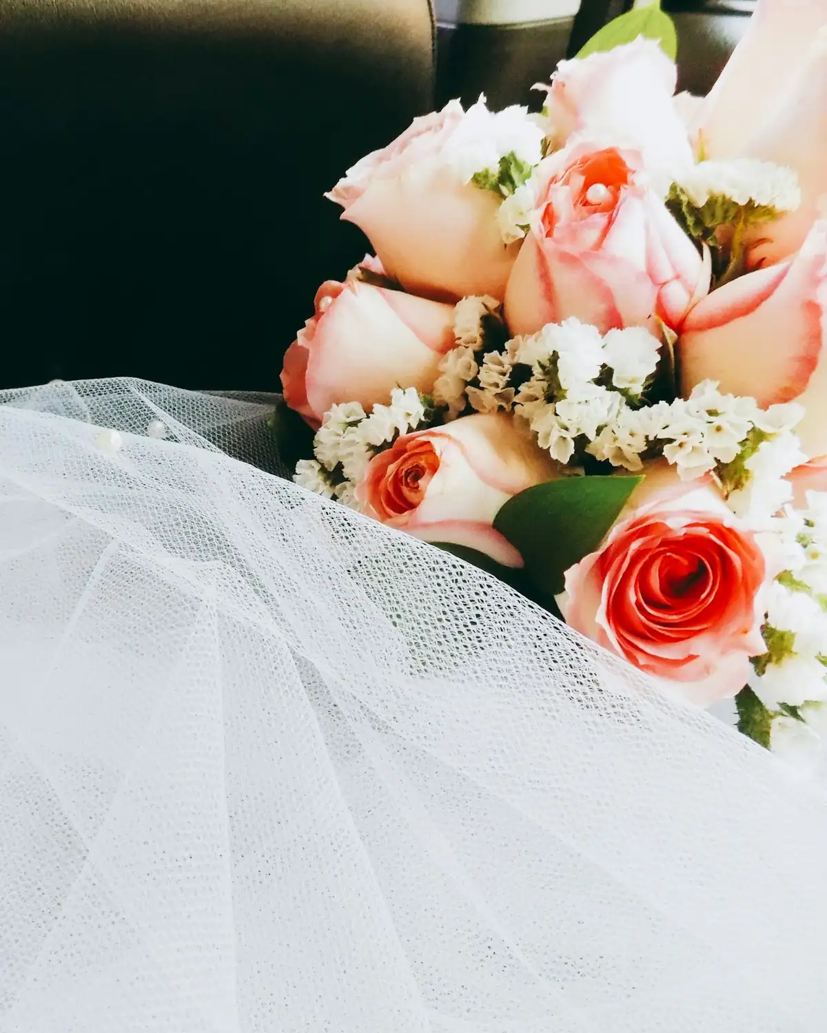 A bouquet of pink roses on a bridal veil