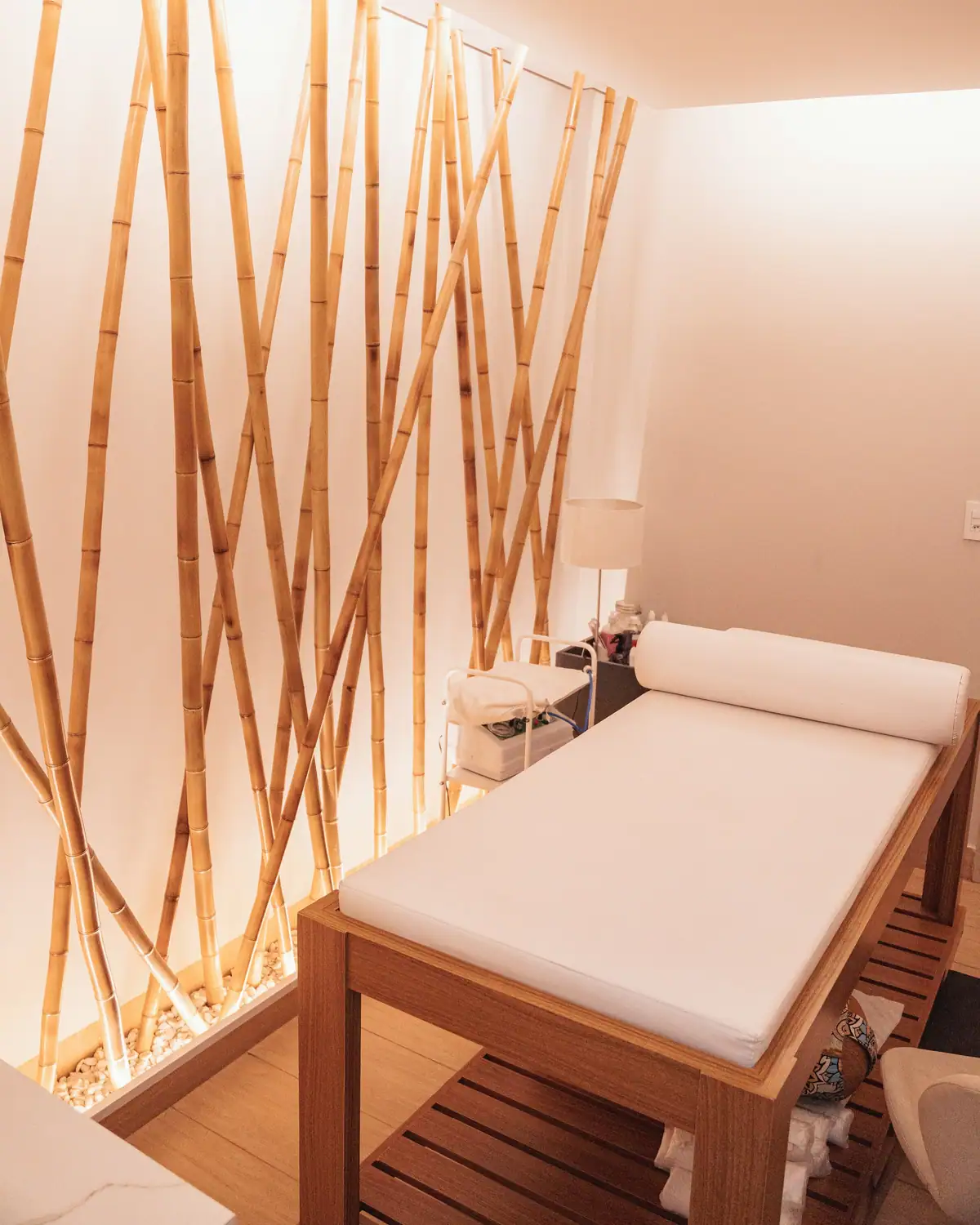 A softly lit massage room with bamboo panels